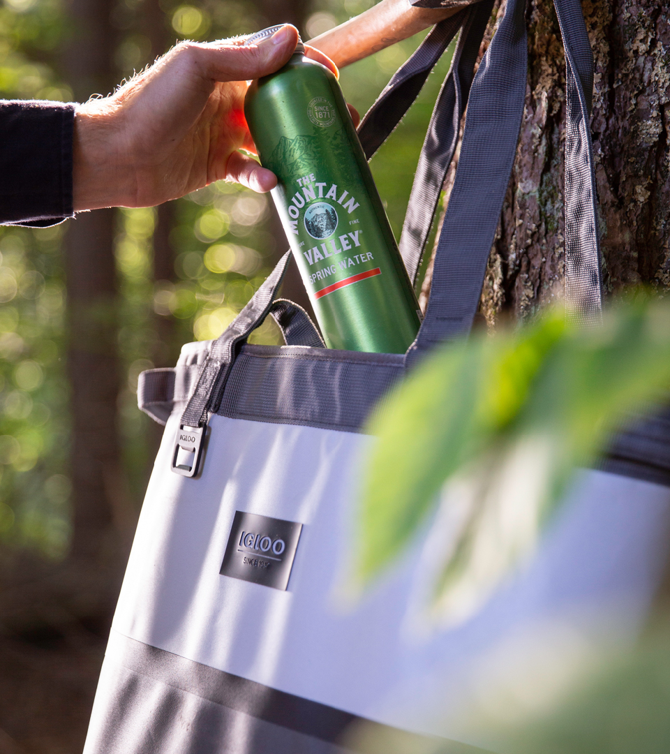 Man pulling Mountain Valley water bottle from a bag