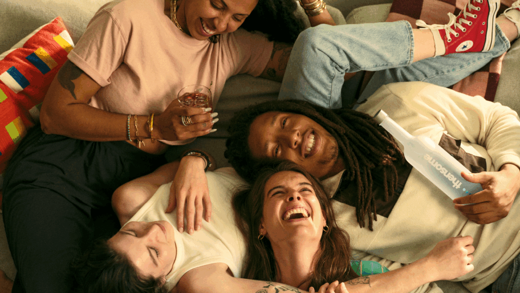 Friends lay on sofa laughing