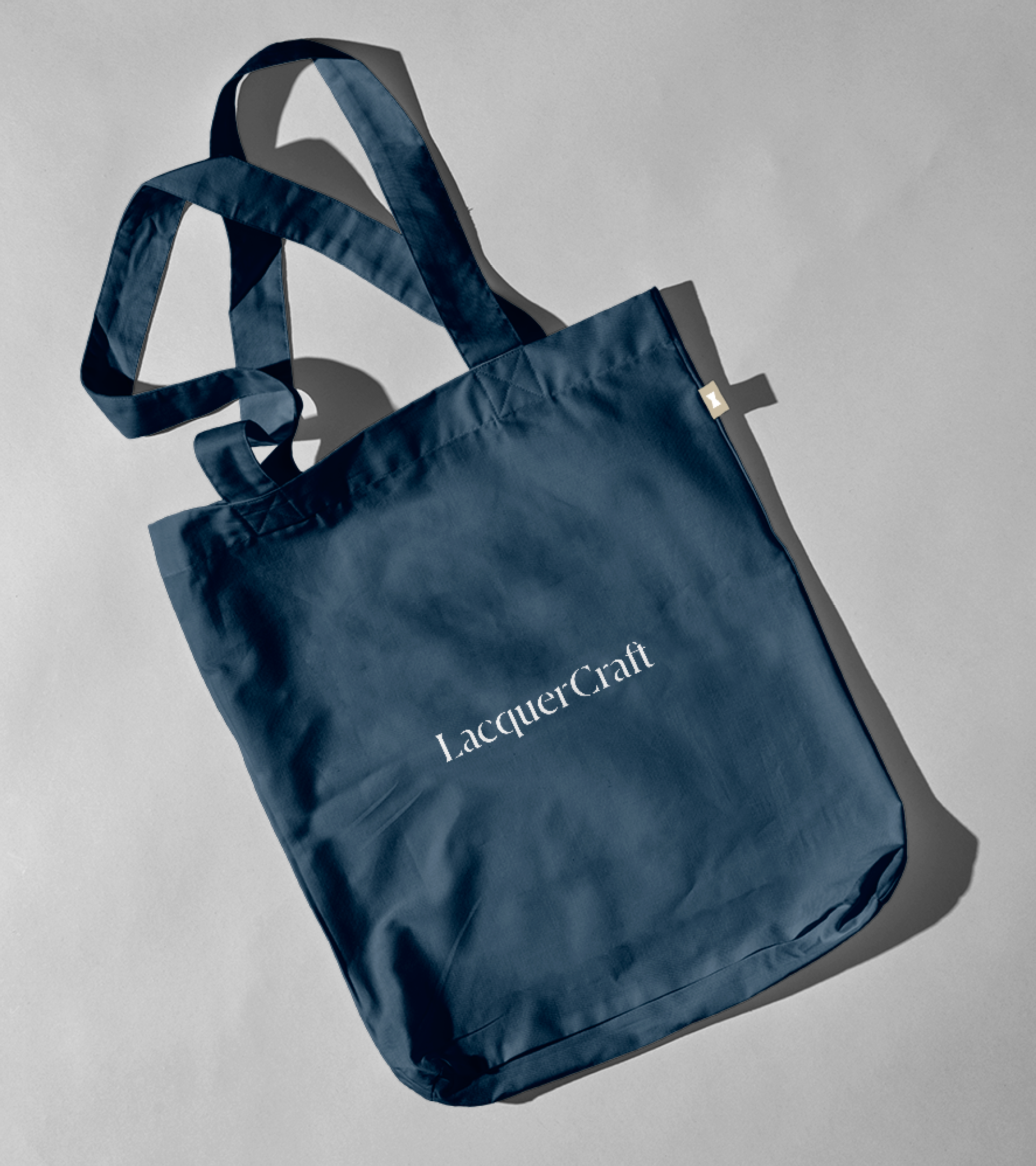 A dark blue tote bacg with Lacquer Craft logo